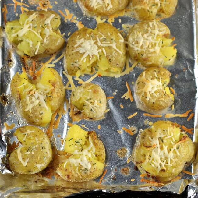 Baked smashed potatoes on a baking sheet.