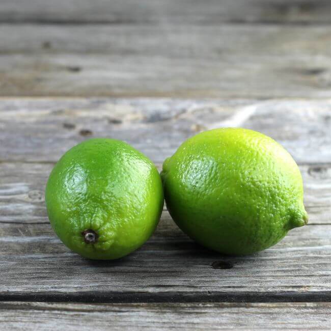 Two limes set on a table.