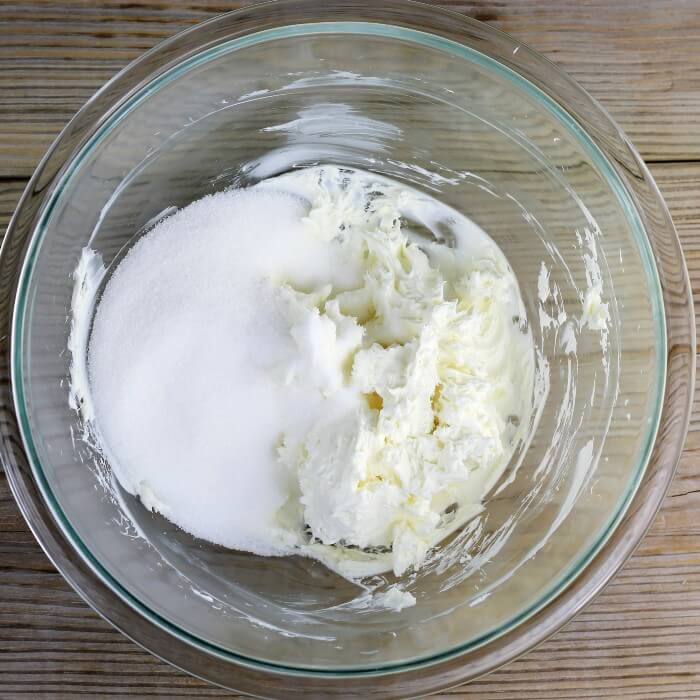 Sugar is added to the beaten cream cheese.