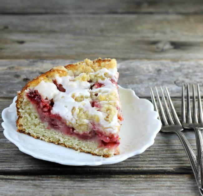 Coffee cake on a white plate with forks on the side of the plate.