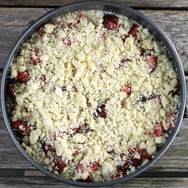 Crumble is sprinkled over top of strawberries.