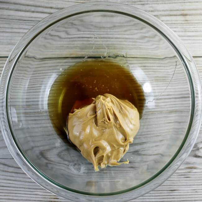 Peanut butter, honey, and vanilla are added to a mixing bowl.