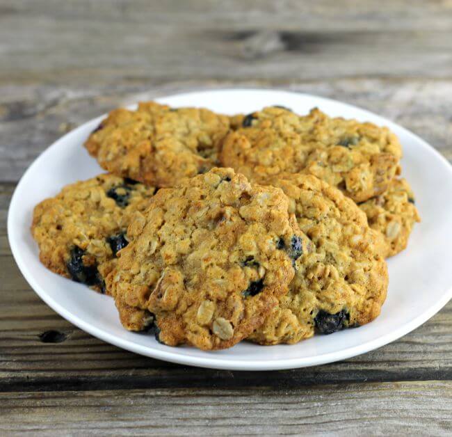 A white plate piled with oatmeal blueberry cookies.