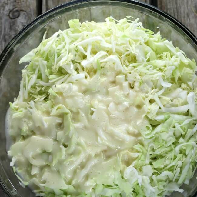 Coleslaw dressing added to the shredded cabbage.
