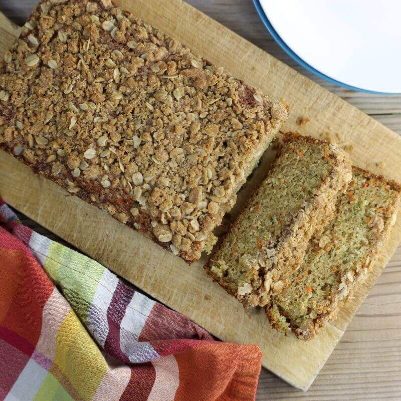 Overlooking a quick bread with a couple of slices on a cutting board.