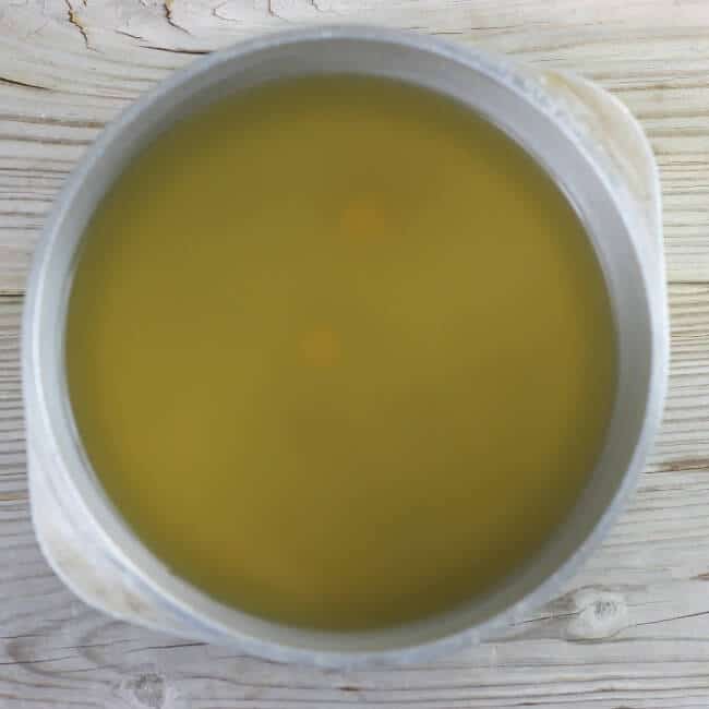 A large kettle with chicken broth and bouillon.