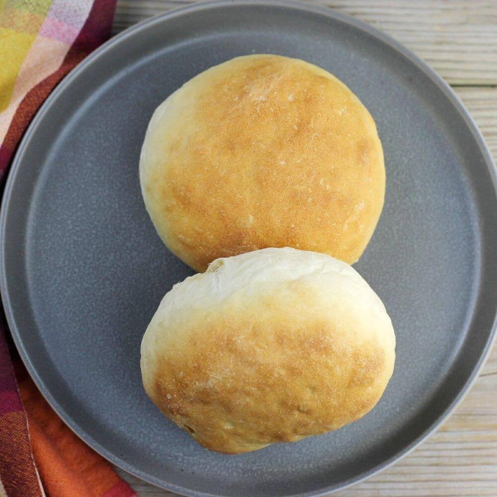 Looking down at a plate with two buns on it. 