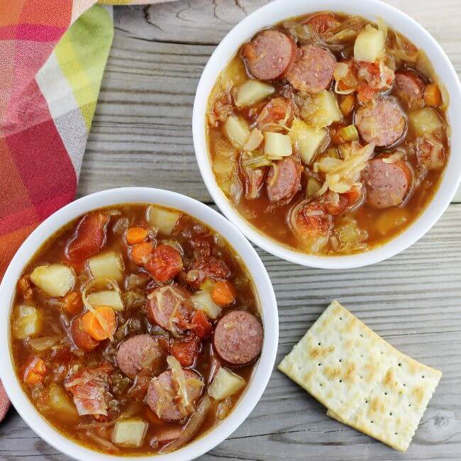 Looking down at to bowls of polish sausage sauerkraut soup.