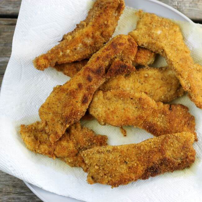 Fried taco chicken strips on paper towels.