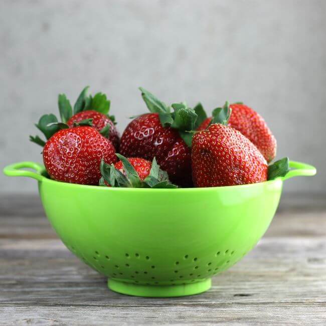 Strawberries in a green bowl.