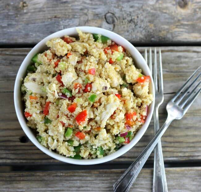 Over lookig a bowl of quinoa salad with two forks on the side.