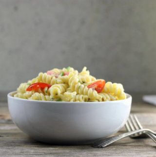 Side view of a white bowl filled with pasta.