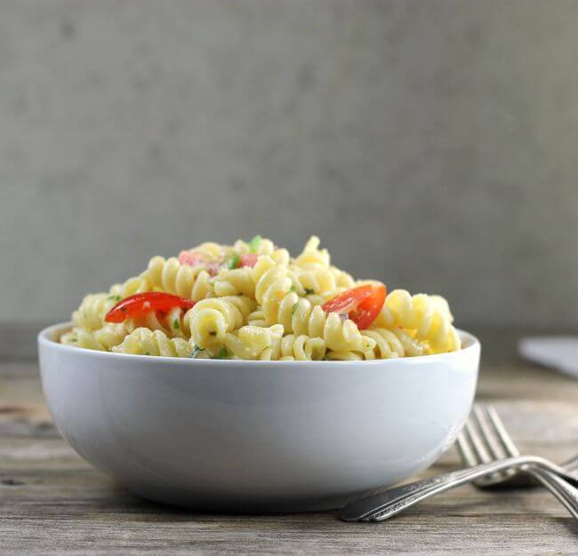 Side view of a white bowl filled with pasta.