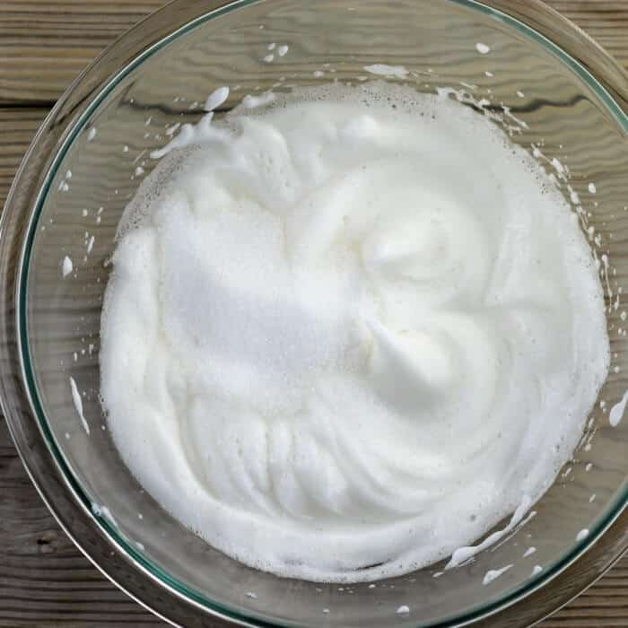 A bowl with egg whites that have been beaten to soft peaks. 