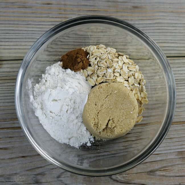 Oats, brown sugar, flour, and cinnamon are added to a small bowl.
