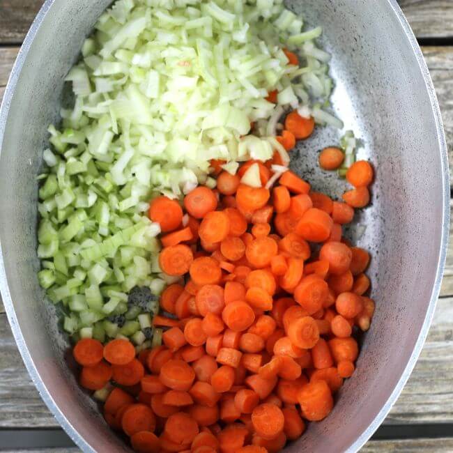 Carrots, celery, and onion added to a Dutch oven.