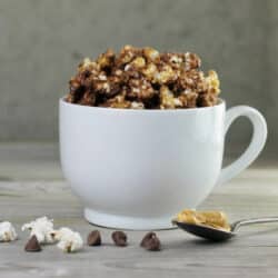 Looking at a side view of a mug filled with chocolate peanut butter popcorn.