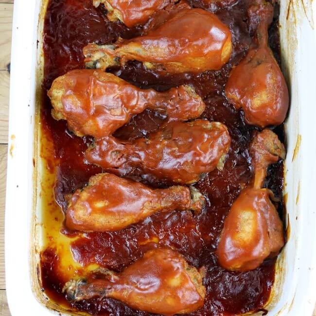 Baked bbq chicken in a white baking dish.