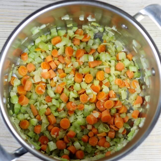 Sauteed vegetables in a large soup pot.