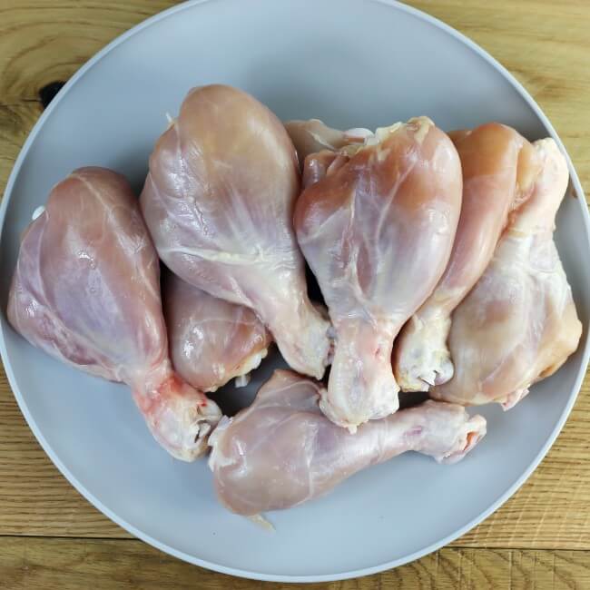 Skinless chicken drumstick on a gray plate.