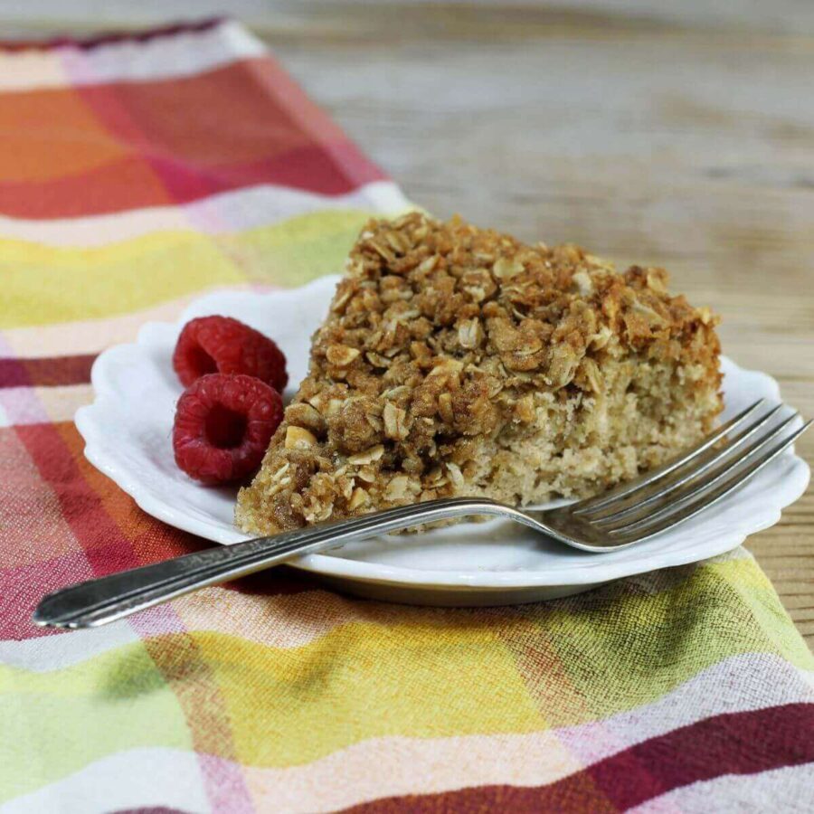 A side angle view of a slice of coffee cake on a white plate.