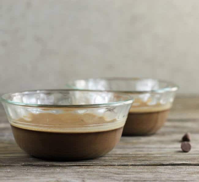 A side view of two bowls of baked chocolate pudding. 