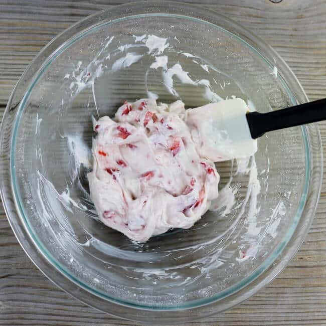 Strawberries are folded into the cream cheese mixture.