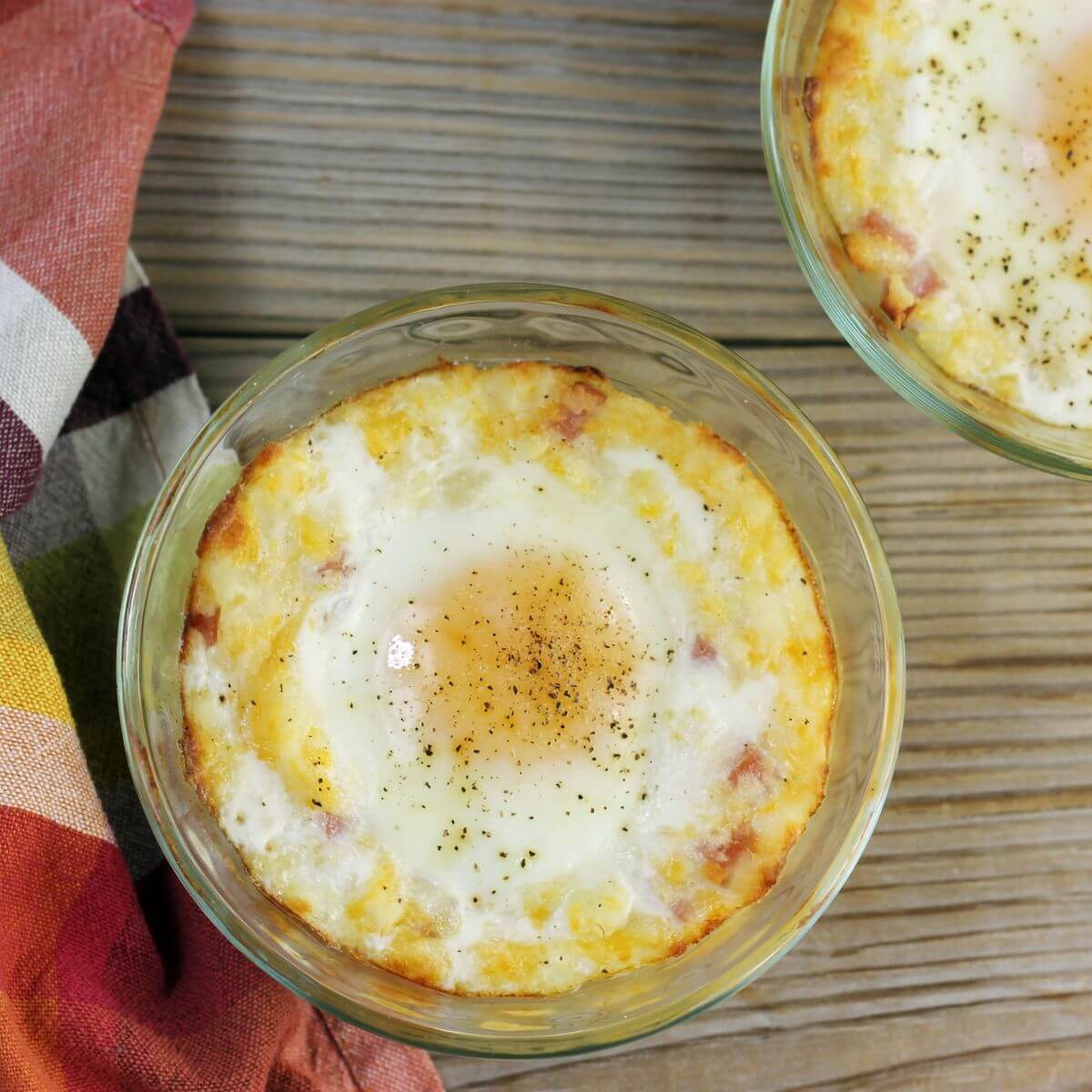 Looking down a custard cups filled with baked mashed potatoes and an egg on top.