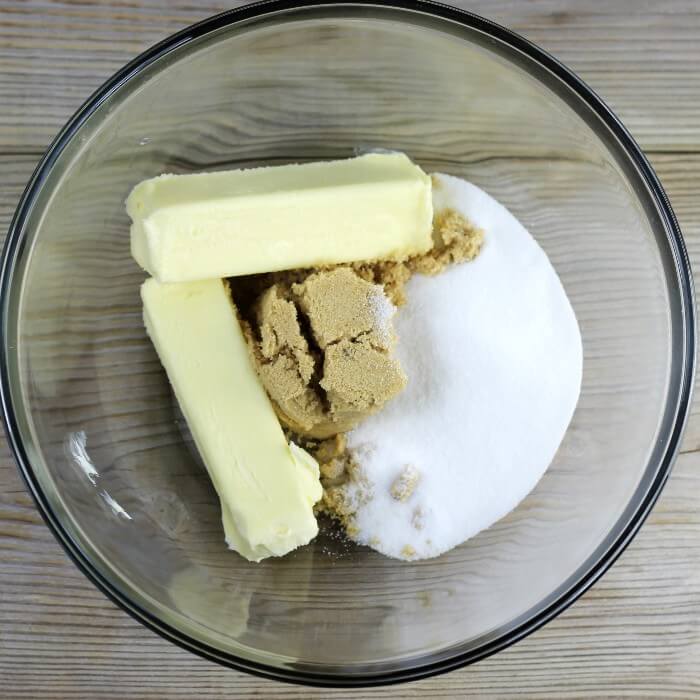 Butter and sugars are added to a large mixing bowl.