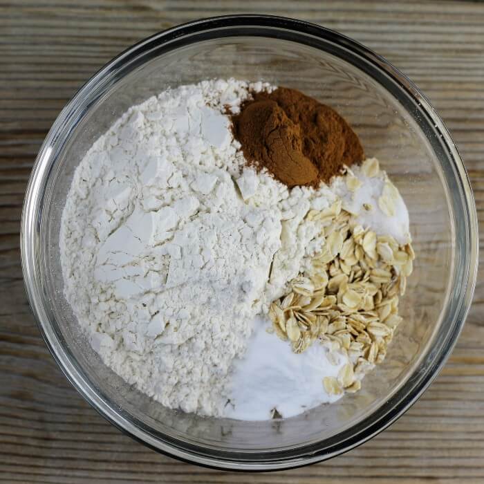 Flour, oats, cinnamon, baking soda, and salt are added to a bowl.