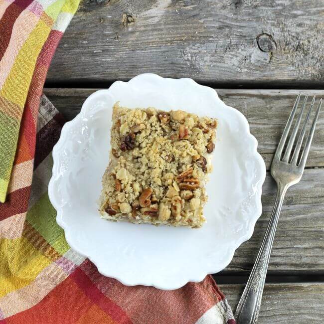 The top of a pear cream cheese bar on a white plate with fork and napkin.