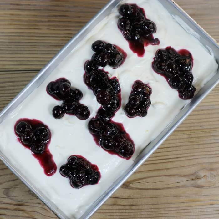 The blueberry that were cooked are place on top of the ice cream mixture.