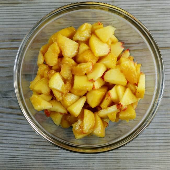 Diced peaches in a small mixing bowl.
