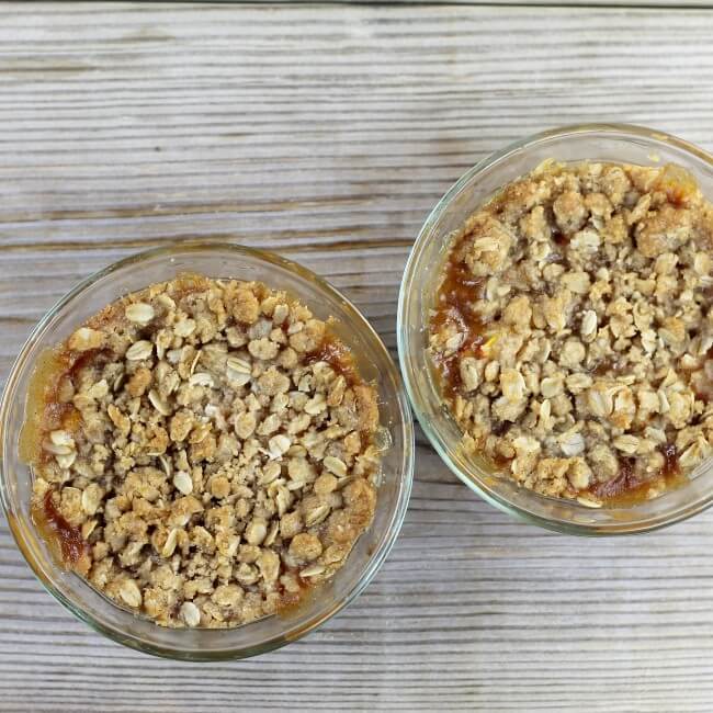Two bowls of baked peach crisp.