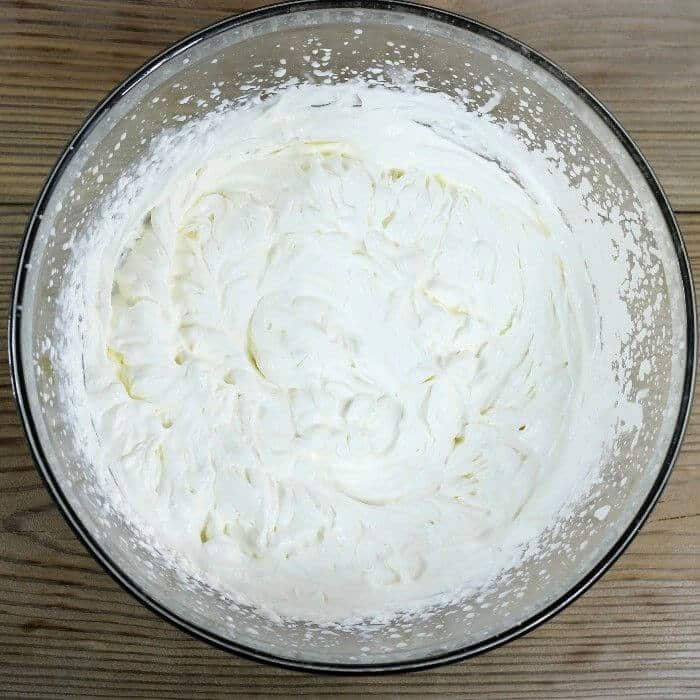 Whipped whipping cream in a large mixing bowl.