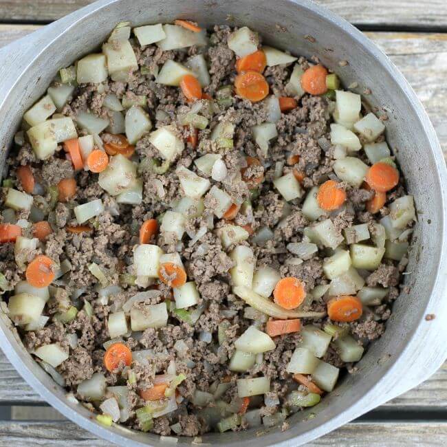 Cooked hamburger and vegetables in a Dutch oven.