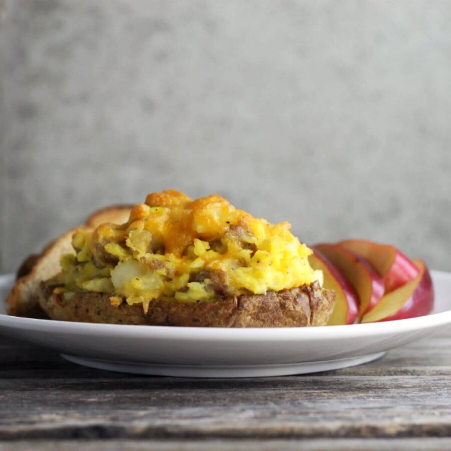 A side view of a stuffed potato on a white plate.