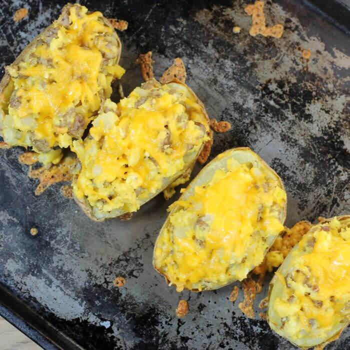 Looking down at a baking sheet with stuffed breakfast potato skins. 