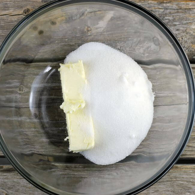 Butter and sugar in a glass bowl.