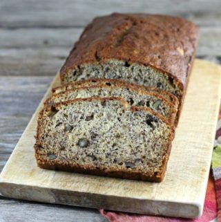 Loaf of banana bread with some slice of the bread on a cutting board.