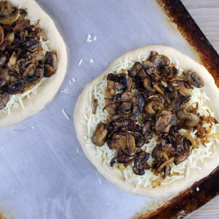 Caramelized onions and mushrooms are added to the top of the cheese.