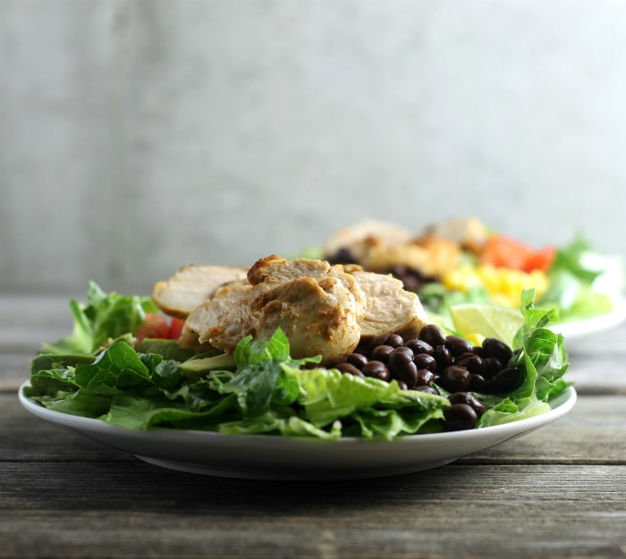 Southwest chicken salad topped with corn, tomatoes, black beans, avocados, and ranch dressing