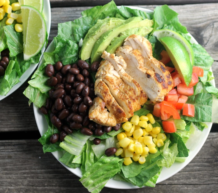 Southwest chicken salad topped with corn, tomatoes, black beans, avocados, and ranch dressing
