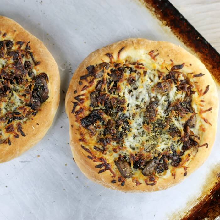 Two baked pizzas on a baking sheet. 