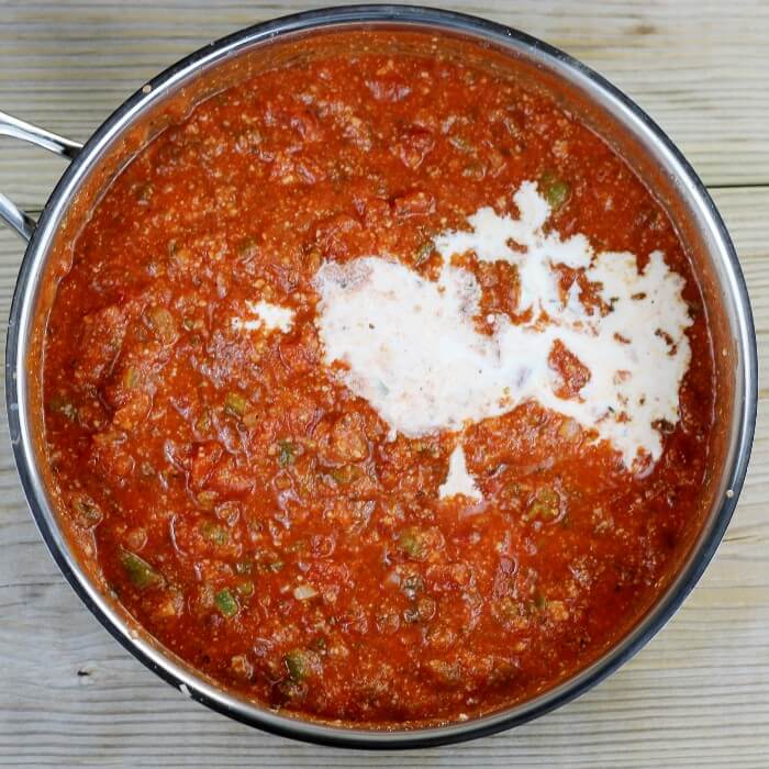 Cream is poured into the red sauce mixture.