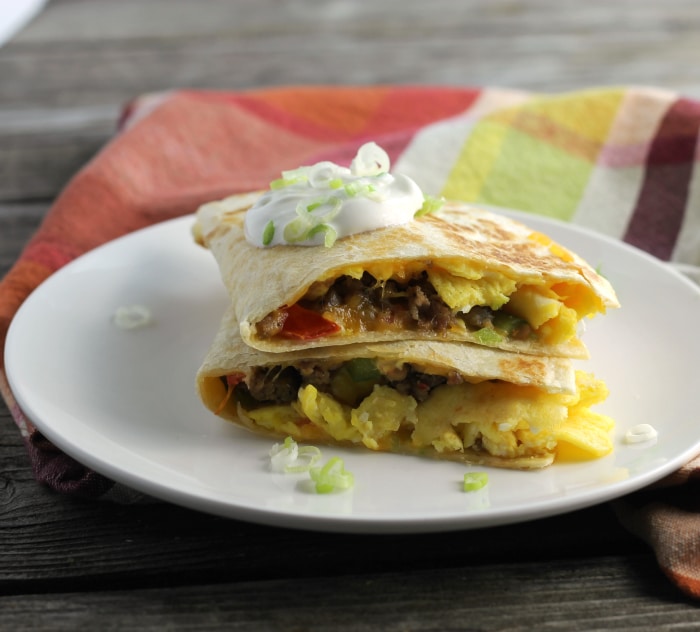 Breakfast quesadillas stuffed full of eggs, sausage, tomatoes, green peppers, onion, and cheddar cheese.