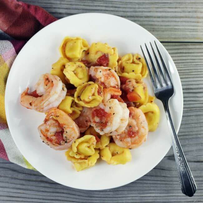 Looking down at a plate of shrimp and pasta.