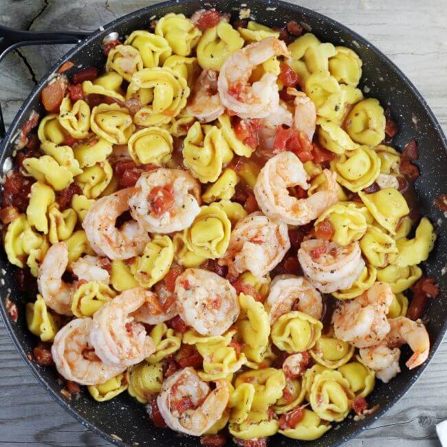 Garlic shrimp tortellini in a skillet. 