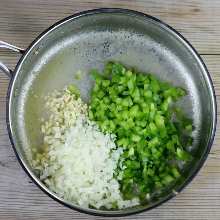 Onion, green pepper, and garlic are added to the skillet.