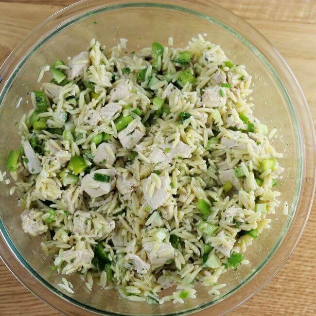 Looking down at a bowl of easy chicken orzo salad.